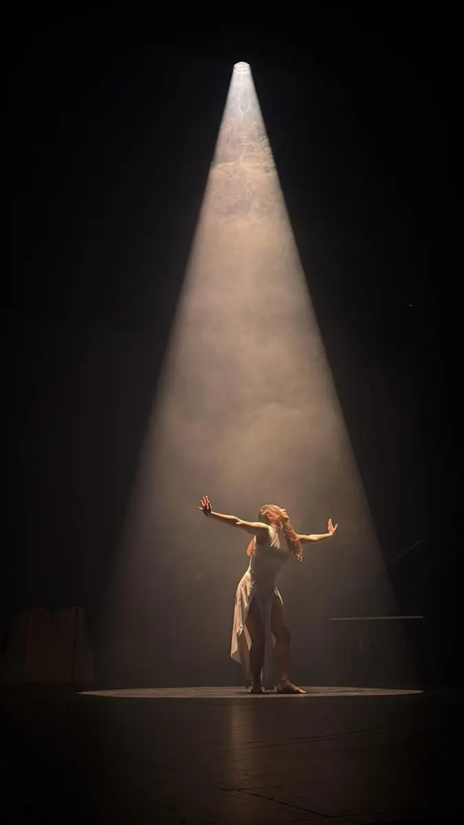 Danseuse seule sous une douche de lumière